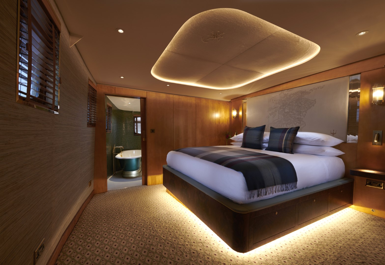 Skerryvore Hotel Suite aboard Fingal Hotel in Edinburgh featuring a super king-size bed with tartan accents, warm lighting, and an en-suite bathroom with elegant design.